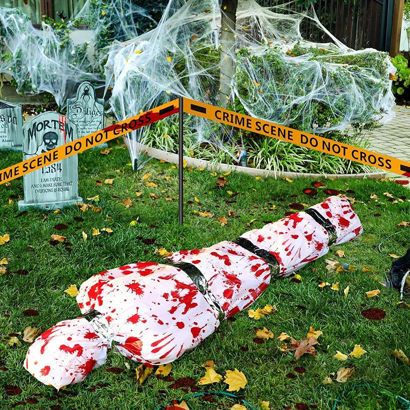 Bloody wrapped corpse Halloween prop with spider webs and crime scene tape