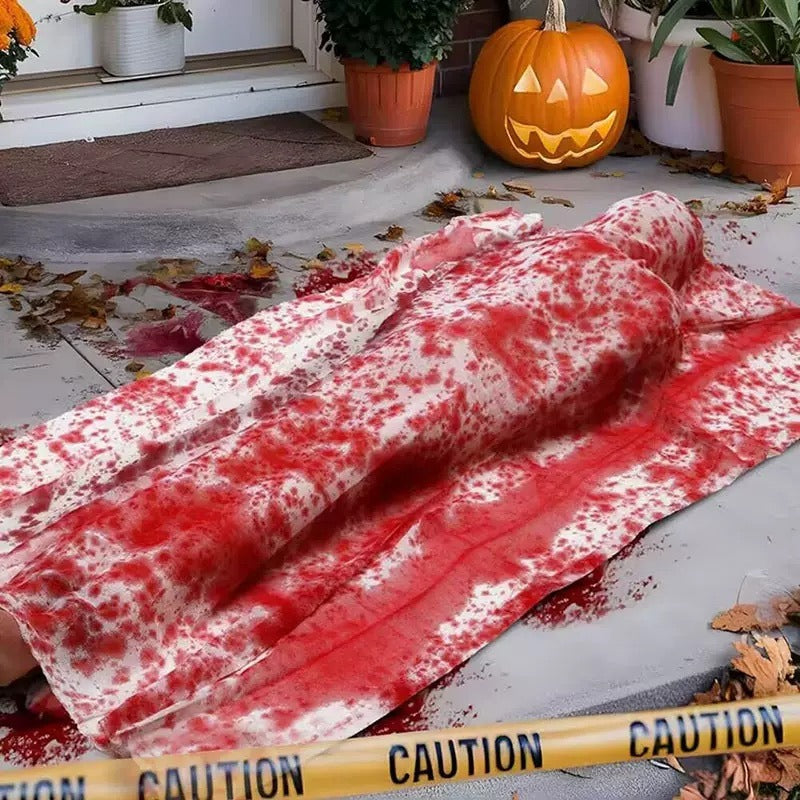 Bloody wrapped corpse Halloween body prop displayed on a porch