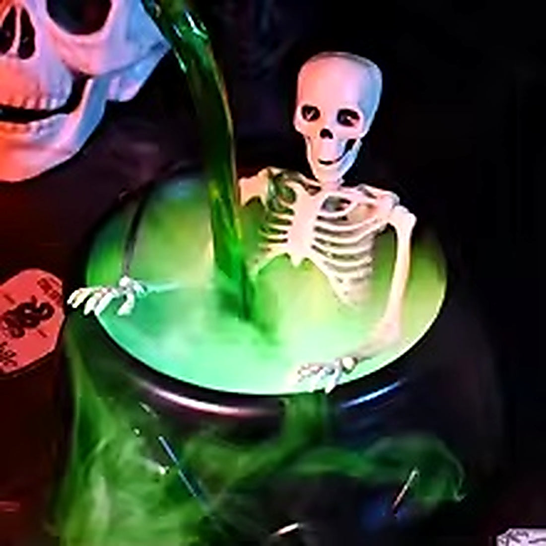 Magic floating potion bottle pouring into glowing Halloween cauldron