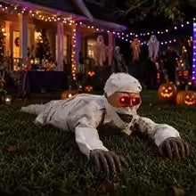 Animated crawling mummy with red LED eyes in a Halloween yard display